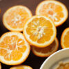 Preparation for making a small batch of homemade bitter orange marmalade in a domestic kitchen. Ingredients: Seville oranges (using the whole fruit, including peel and pips), Amalfi lemon juice and pips, preserving sugar, and water.